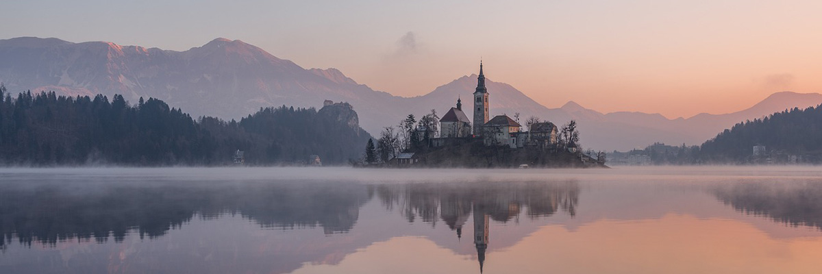 Mañana de niebla de la iglesia y la isla del lago Bled