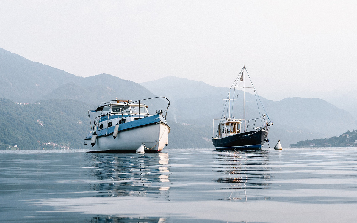 Coastal road near white towns in Puglia and boats at the sea