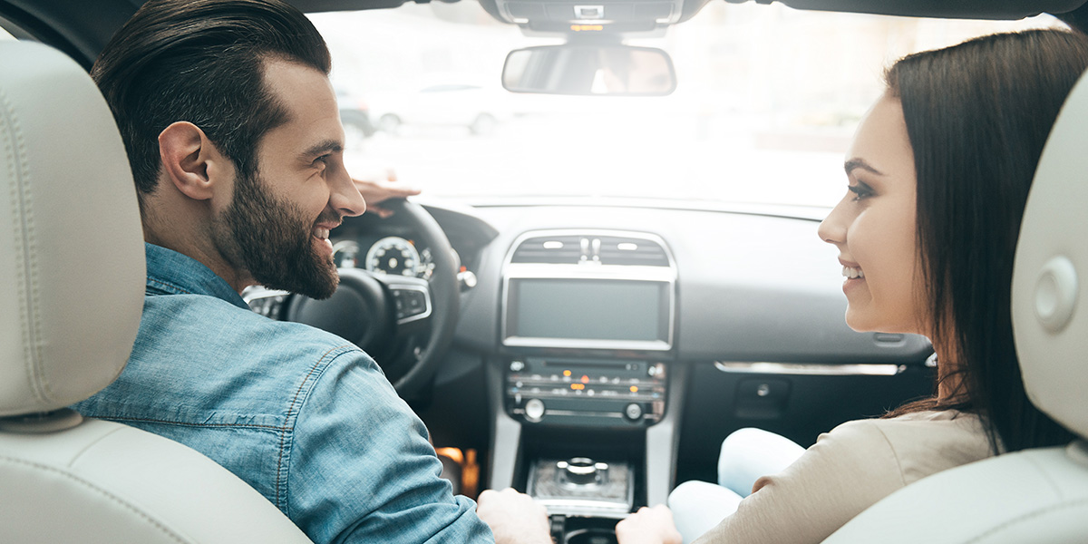 Coppia in viaggio in Italia con un’auto a noleggio, che mostra come i prezzi del noleggio possano variare in base al periodo e alla località.