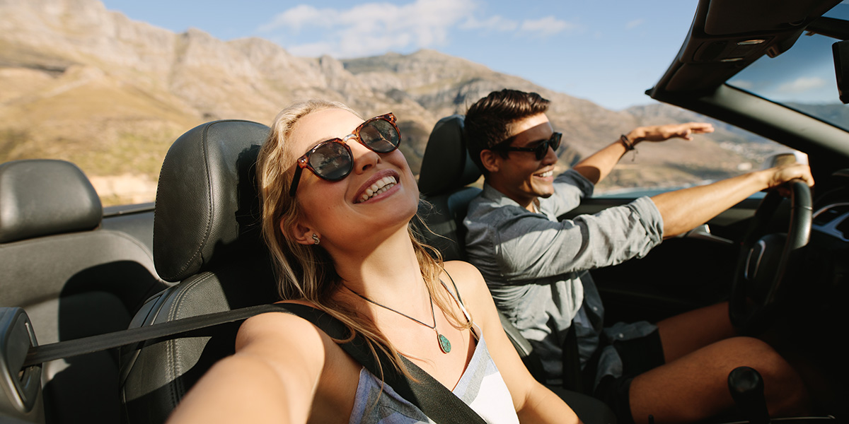 Coppia felice in viaggio su una cabrio in Italia, un chiaro esempio di quando noleggiare un’auto in Italia è davvero una buona idea