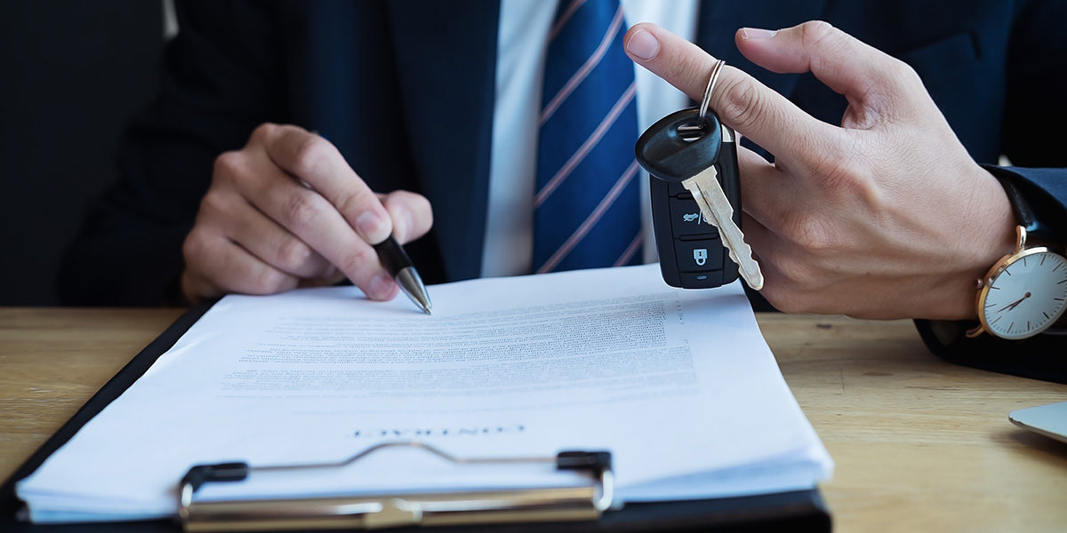 Firma del contratto di assicurazione per il noleggio auto in Italia.