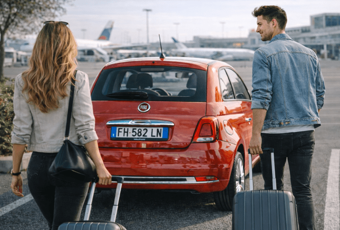 Popotniki, ki se na letališču Neapelj v Italiji odpravljajo proti svojemu najetemu avtomobilu, rdeči Fiat 500
