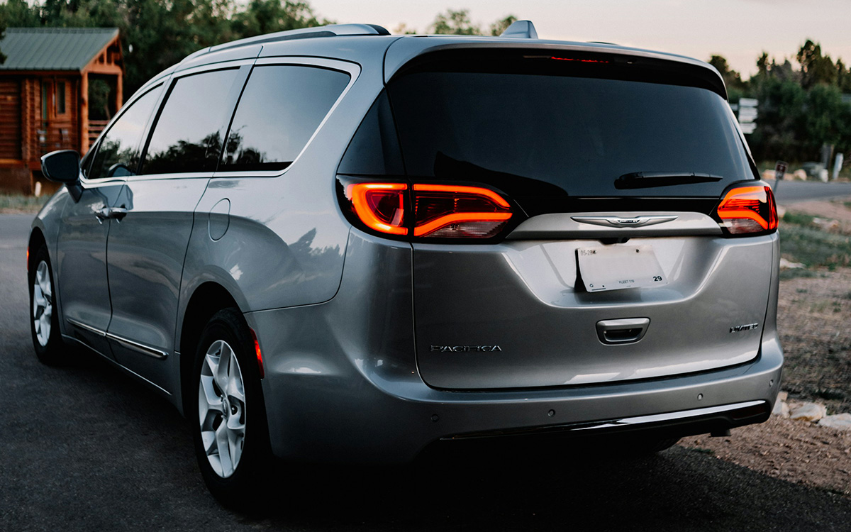 Familien-Kleinbus auf dem Land geparkt, mit Fokus auf das Heckdesign und den praktischen, gepäckfreundlichen Stauraum für Gruppenreisen