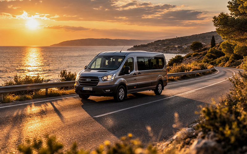 noleggio auto 8 posti spazioso su strada costiera, van passeggeri che percorre la costa durante un viaggio al tramonto (golden hour)