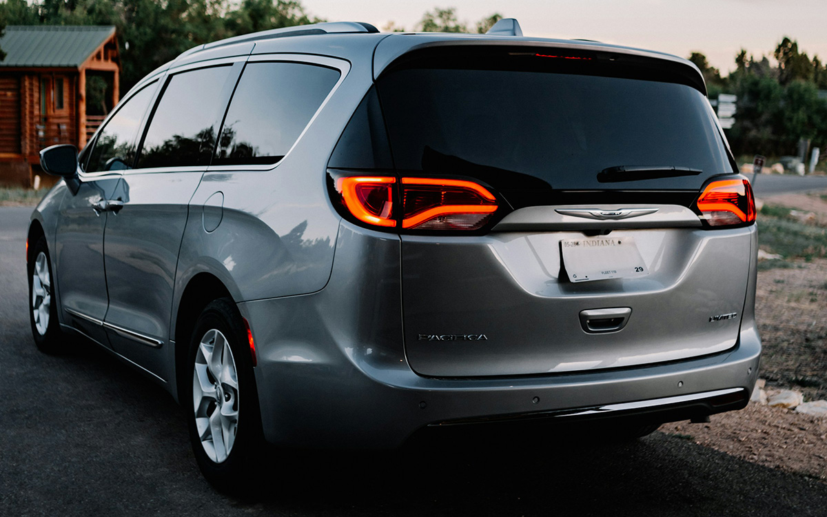 rear view of spacious minivan parked on roadside at sunset with illuminated tail lights