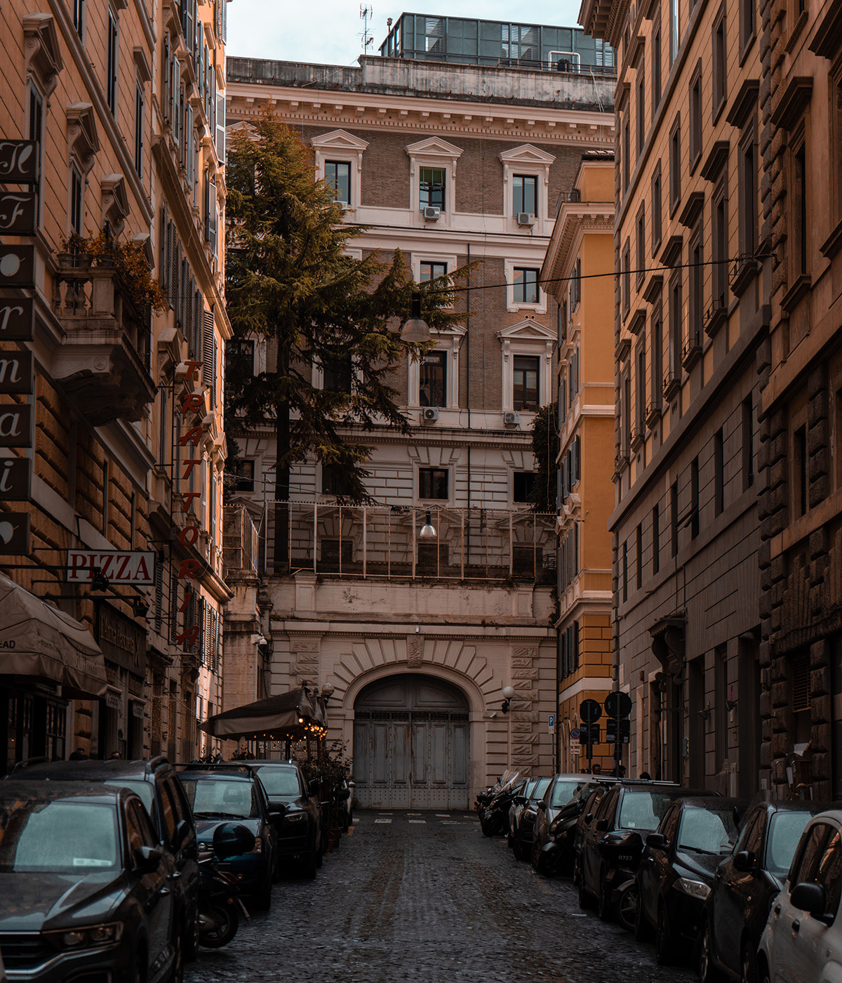Cars parked along a quiet residential street surrounded by historic Italian buildings