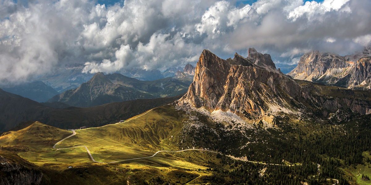 Panoramic view of the Italian Dolomites with scenic mountain roads and dramatic peaks.