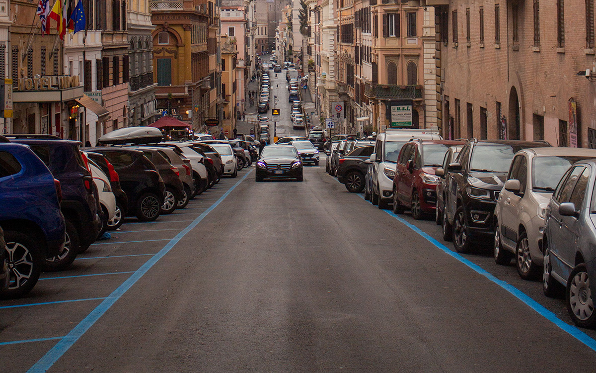 Parking in Italy, blue parking spaces lining a busy urban street in Rome