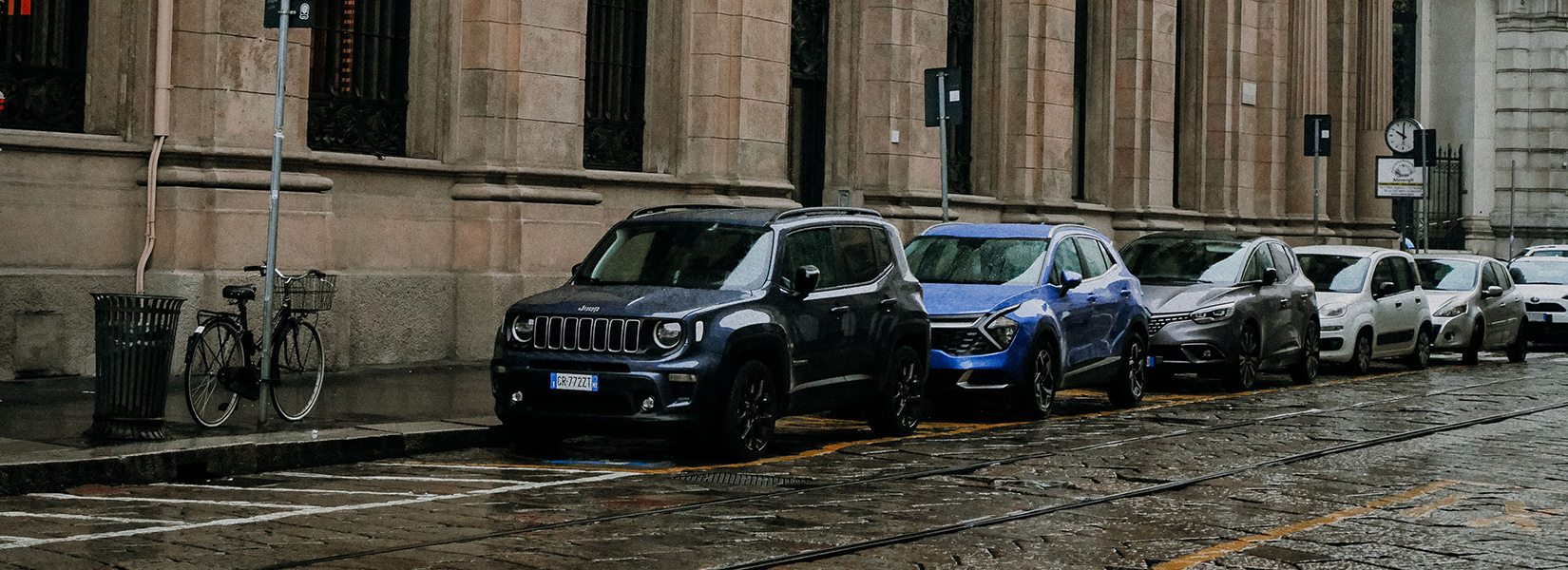 Parking in Italy, cars parked along a historic city street with marked parking spaces