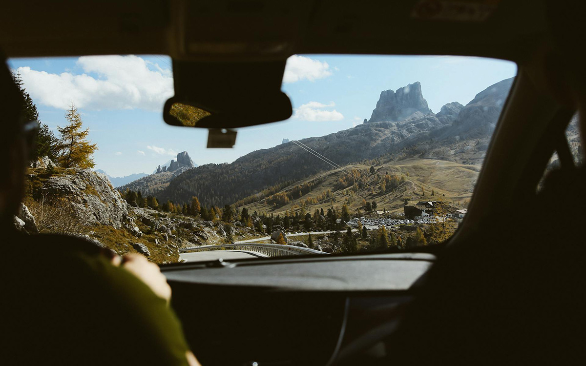 Scenic mountain road viewed from inside a car while driving in Italy through the Dolomites.
