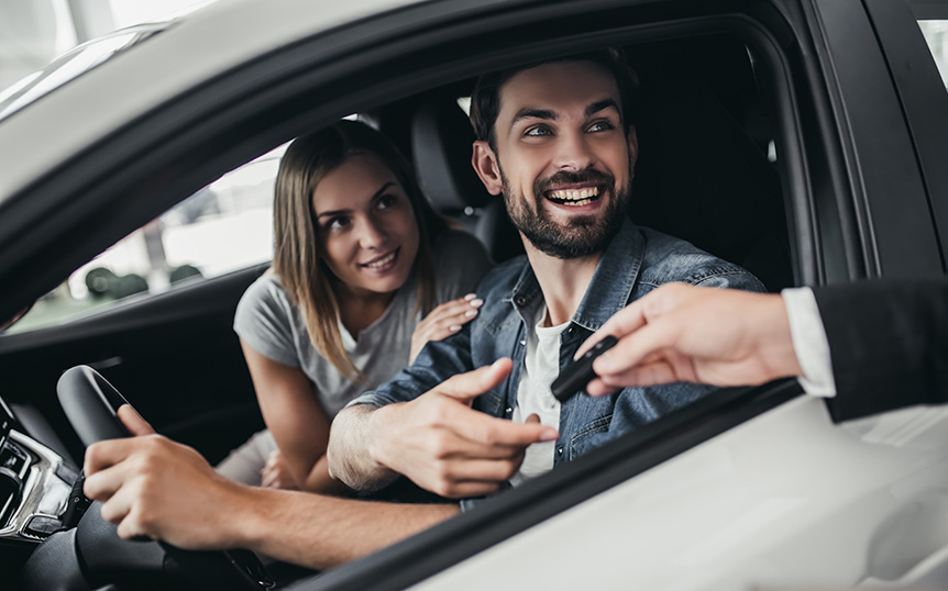 Couple in a rental car receiving the car keys at pickup