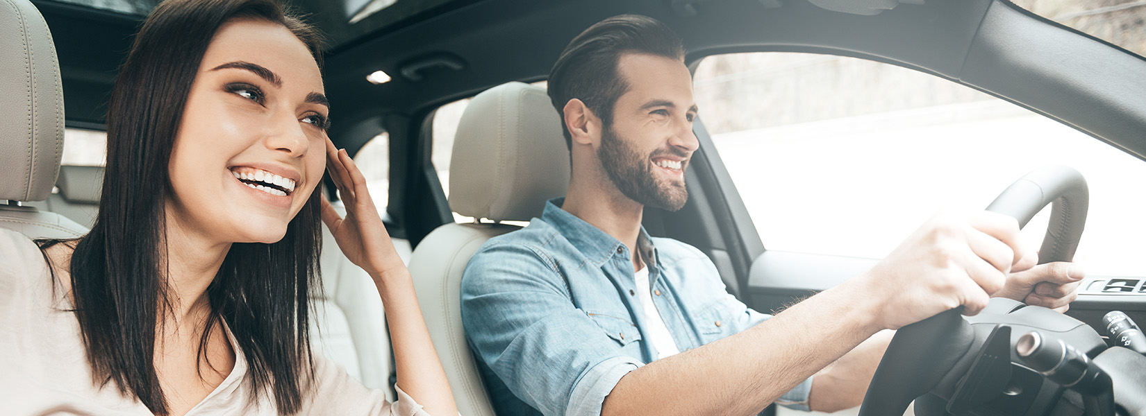 Visitteo About Us – happy couple driving a rental car on their holiday trip